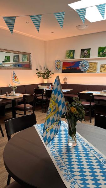 Gedeckter Tisch mit Rautenläufer und Wimpelkette im Gastraum