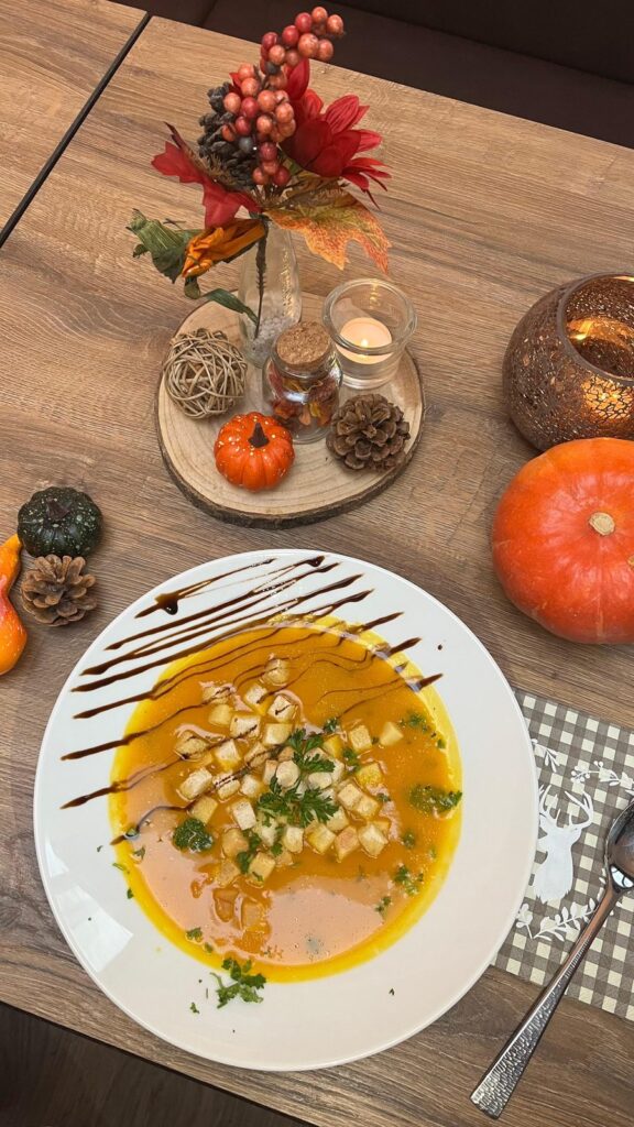 Kürbissuppe mit herbstlicher Dekoration