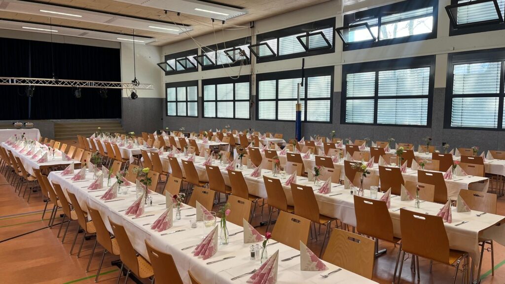 Festsaal mit langen, festlich gedeckten Tafeln